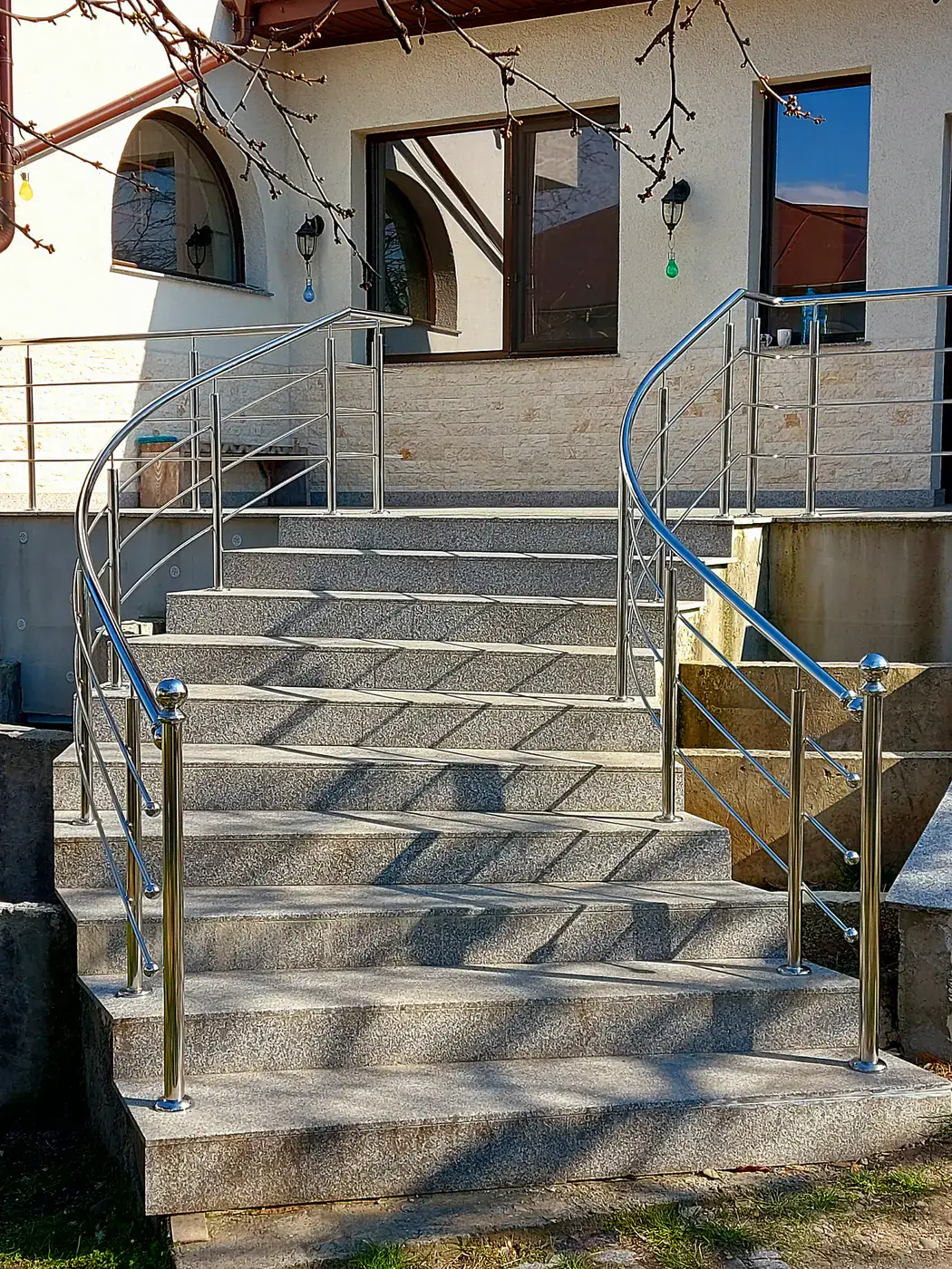 Balustradă reală din inox pe o scară interioară placată cu piatră
