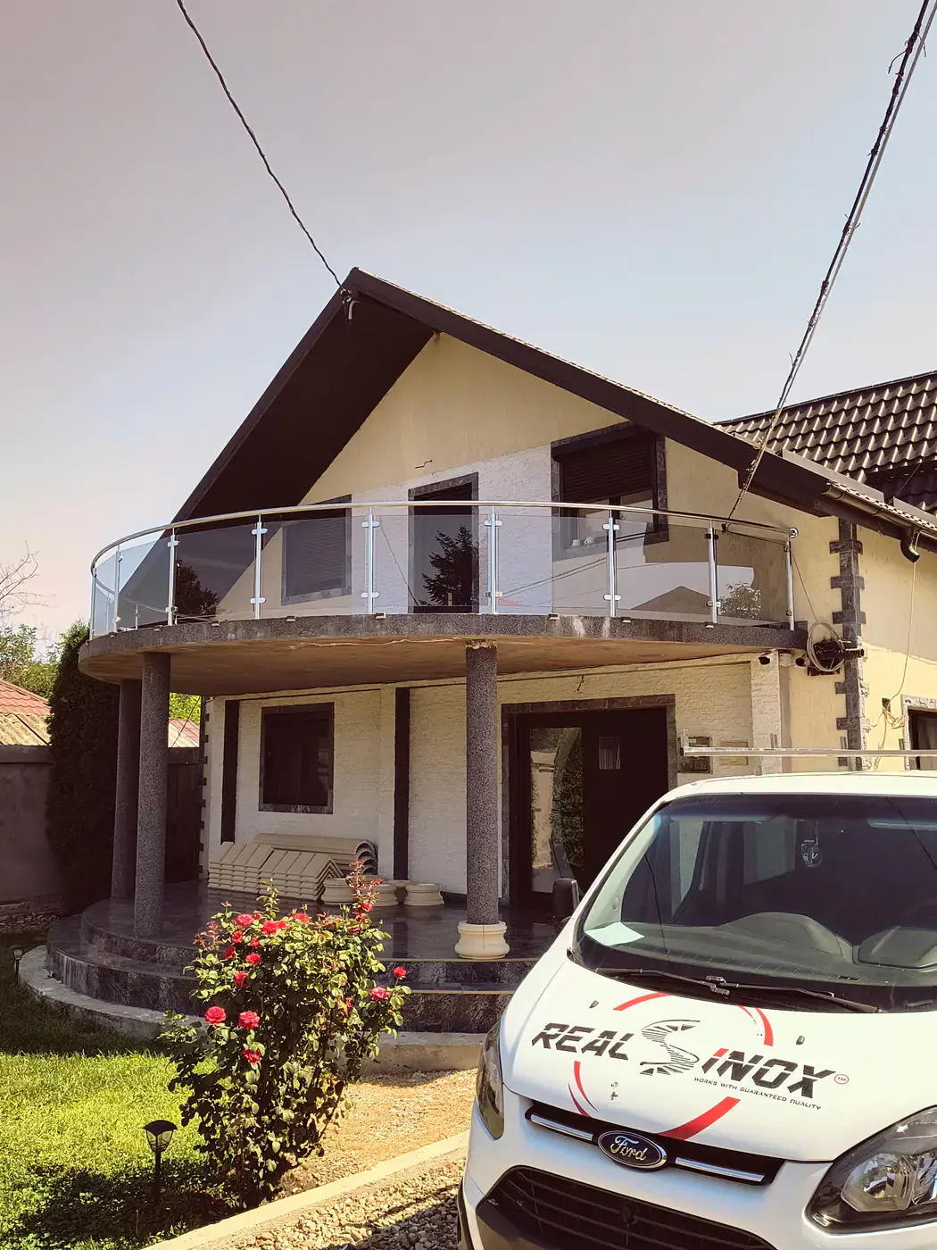 Balustradă reală curbată din inox și sticlă montată la balconul unei case