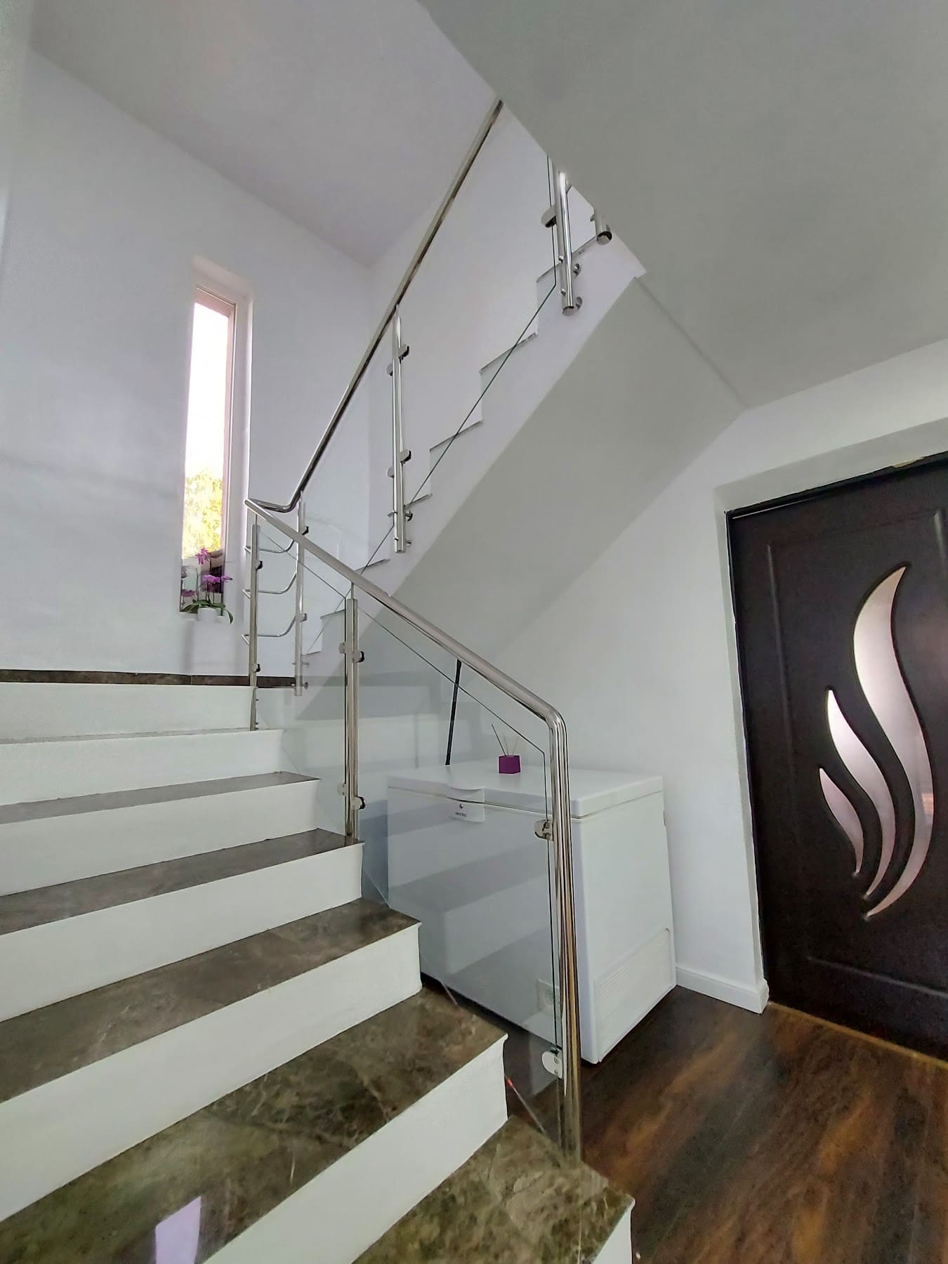 Balustradă reală din inox și sticlă pe o scară albă